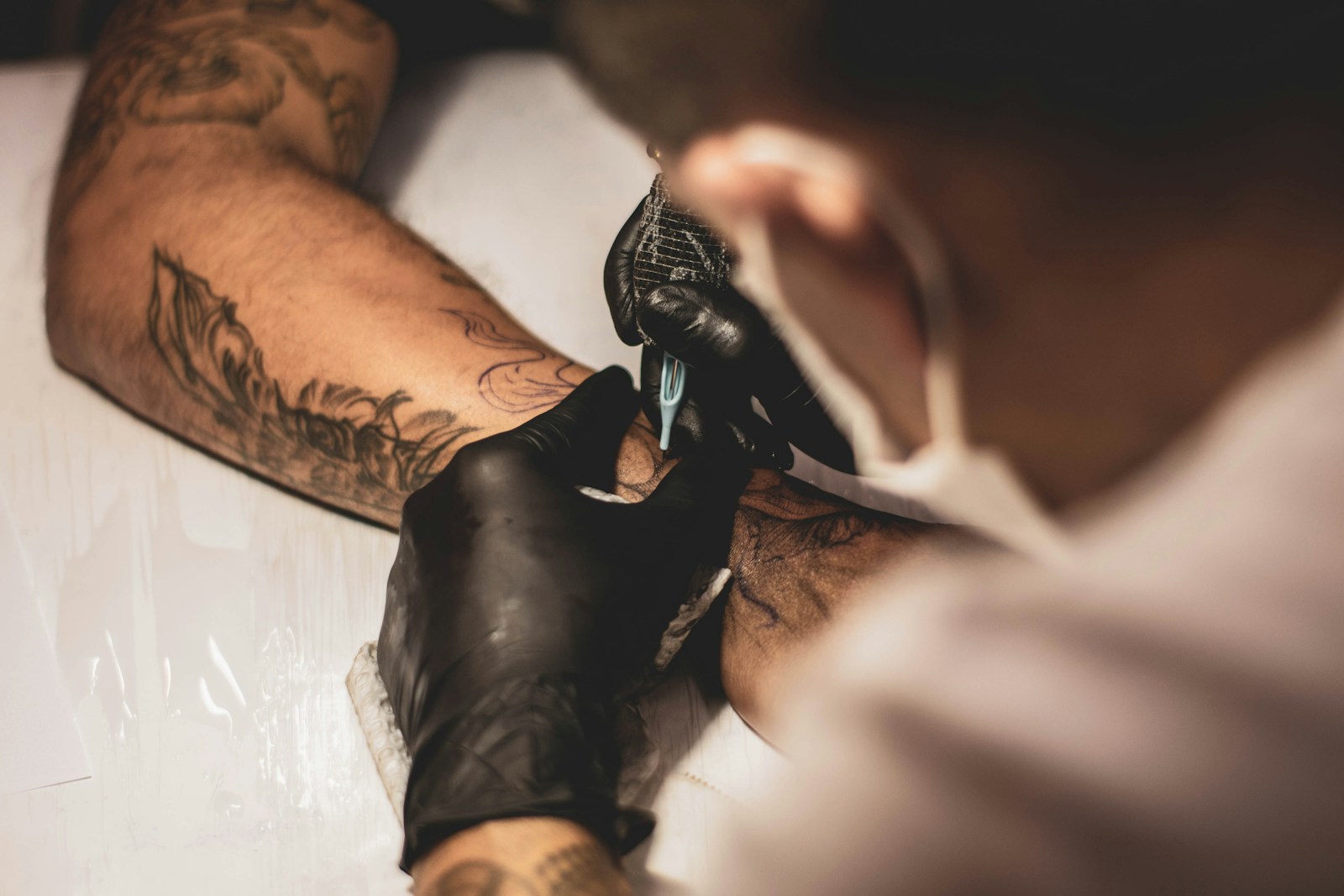 Editorial atmosphere image of a tattooing process; not Inky Apricot portfolio work